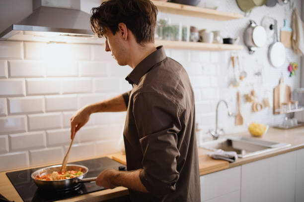 istock Young man cooking in the kitchen 1355298315