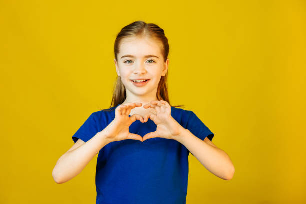 istock kid looking at camera and showing heart sign with hands 1355299652