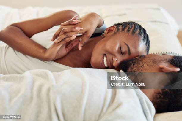 Shot Of A Young Couple Being Intimate In Bed At Home Stock Photo - Download Image Now