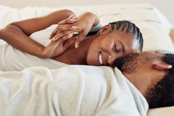 shot of a young couple being intimate in bed at home - couple african descent loving young adult imagens e fotografias de stock