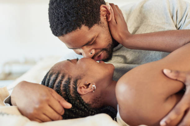 Shot of a young couple being intimate in bed at home stock photo
