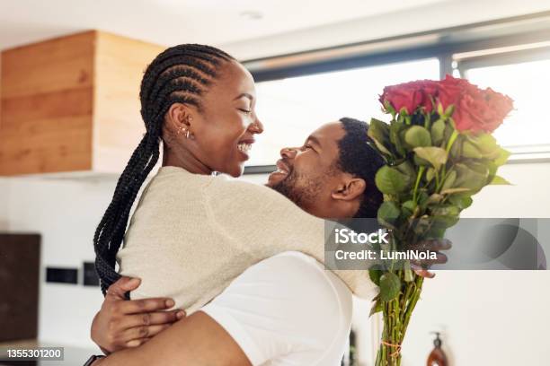 Shot Of A Young Man Surprising His Wife With A Bunch Of Flowers At Home Stock Photo - Download Image Now