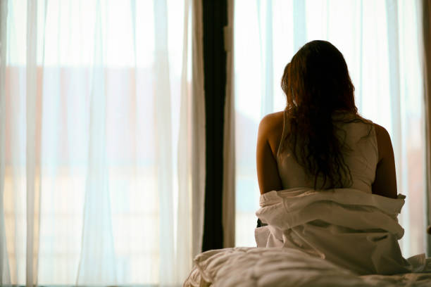 istock Woman sitting on the bed 1355303294