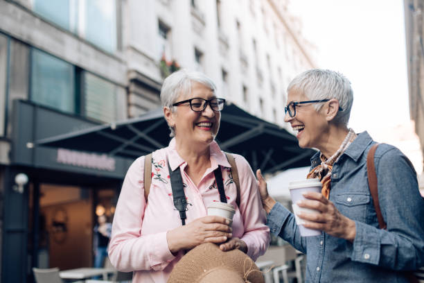 istock Two senior friends on a journey drinking coffee and enjoying their walk 1355303298