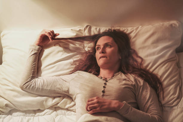 istock Young woman daydreaming on bed 1355303343
