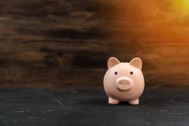 istock Pink piggy bank on a wooden background, copyspace 1355305552