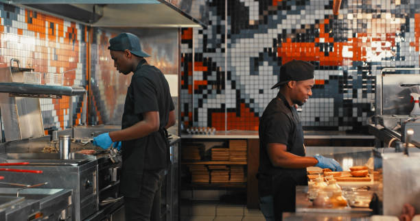 shot of a chef preparing food in a commercial kitchen at a restaurant - commercial kitchen restaurant chef food service occupation imagens e fotografias de stock