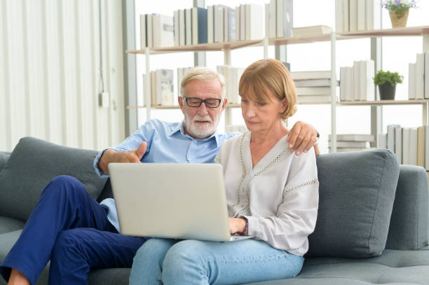 istock Happy Caucasian senior couple using laptop at home 1355306751