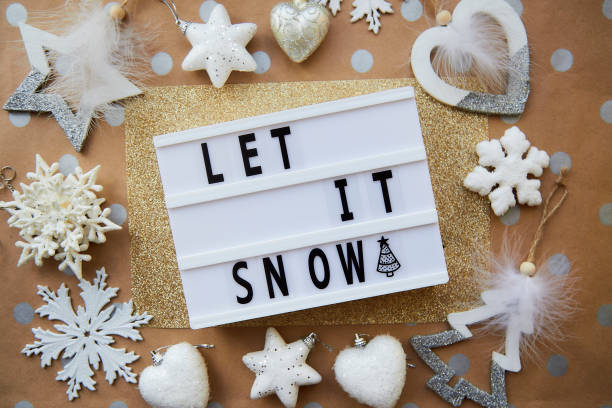 istock Let it snow text with Christmas ornaments. Christmas decorations on dot basic beige and golden background 1355306753
