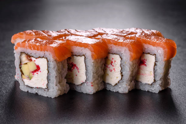 istock Traditional delicious fresh sushi roll set on a black background 1355307110