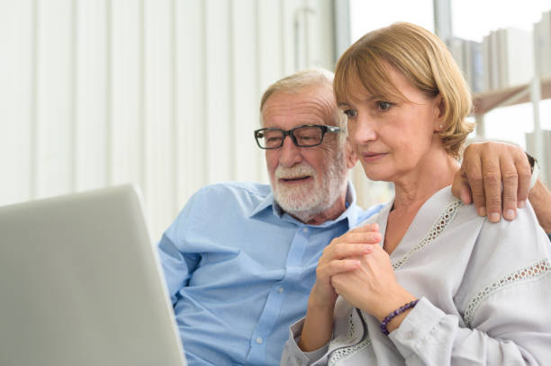 istock Happy Caucasian senior couple using laptop at home 1355308066