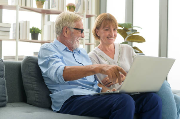 istock Happy Caucasian senior couple using laptop at home 1355308088