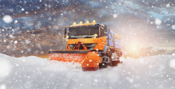 A cleaning vehicle clears the snow from the street - onset of winter A cleaning vehicle clears the snow from the street - onset of winter winterdienst stock pictures, royalty-free photos & images