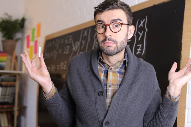 istock Doubtful looking teacher shrugging shoulders 1355317941