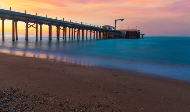 istock Pier leaving the sea at sunset 1355318357