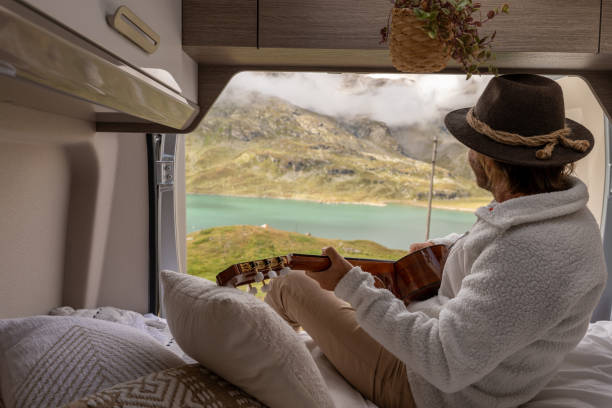 istock Young man in his van playing guitar 1355318757