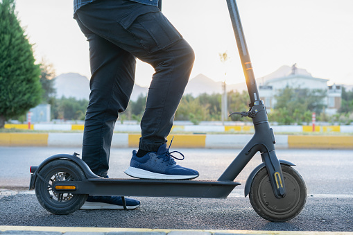 Man waiting in the road with his e-scooter.