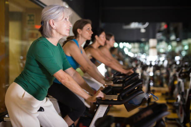 istock Mature woman taking cycling class at gym 1355320307