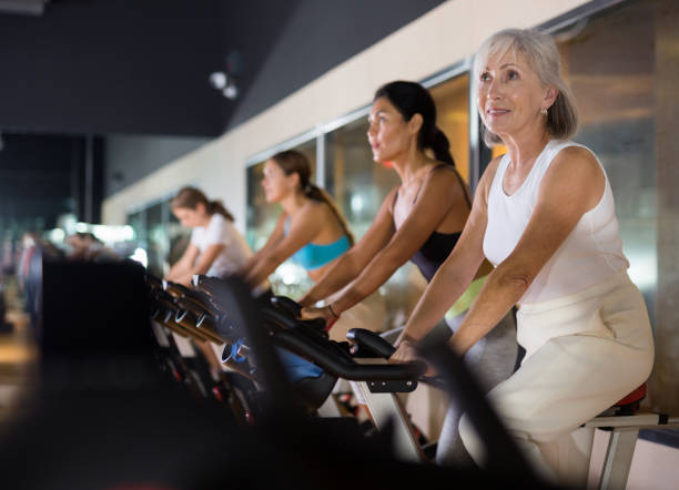 istock Mature woman taking cycling class at gym 1355320331