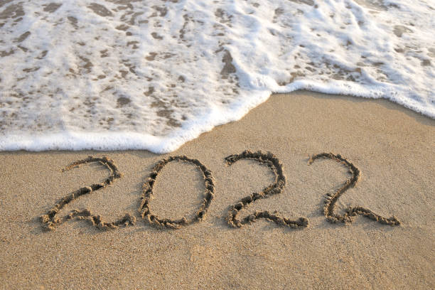 istock 2022 year written on sandy beach sea. Top view. Flat lay. 1355321101