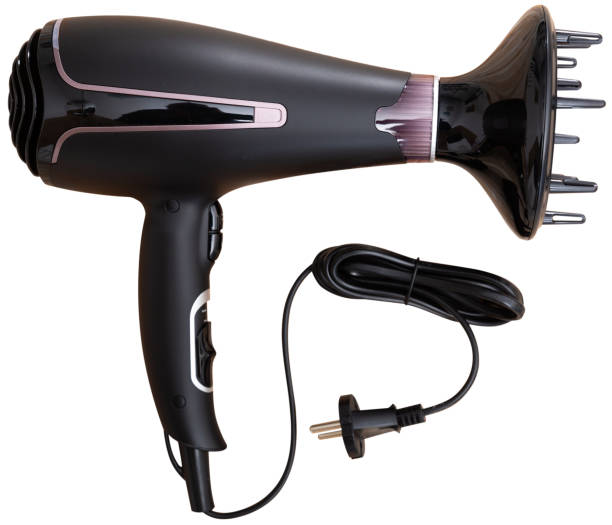 A fashionable woman using a hairdryer to blow her hair under the shadow of light and shadow