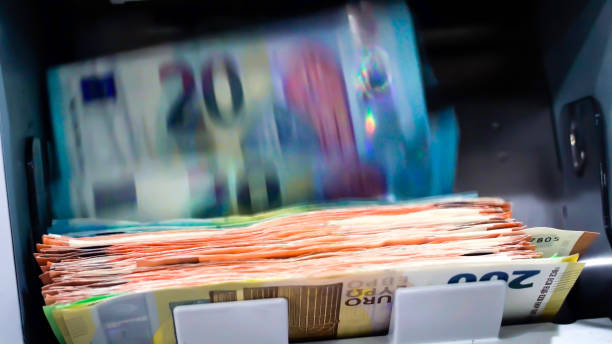 die euro-banknoten in einer währungszählmaschine - coin bank stock-fotos und bilder