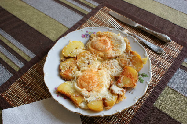 istock fried eggs on a plate. scrambled eggs with cheese and paprika on fried potatoes 1355323174