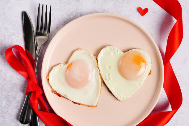 istock Heart shape fried eggs on the pink plate with red heart 1355326927