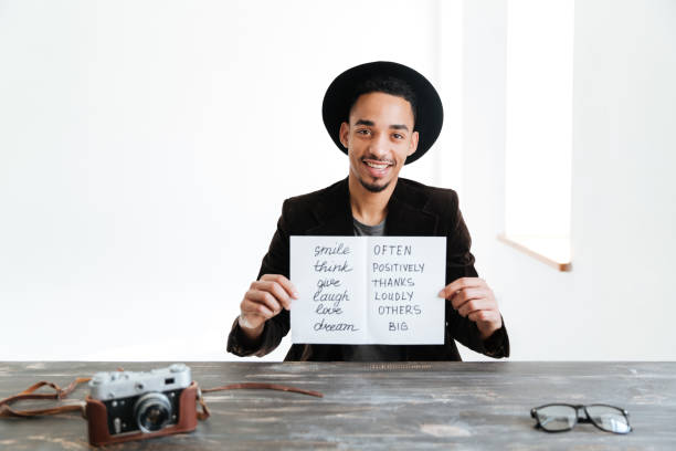 istock African man holding sheet of paper with words 1355328047