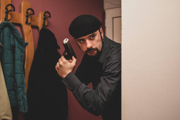 istock Young armed detective working on a case in apartment where potential murder has occured 1355329272