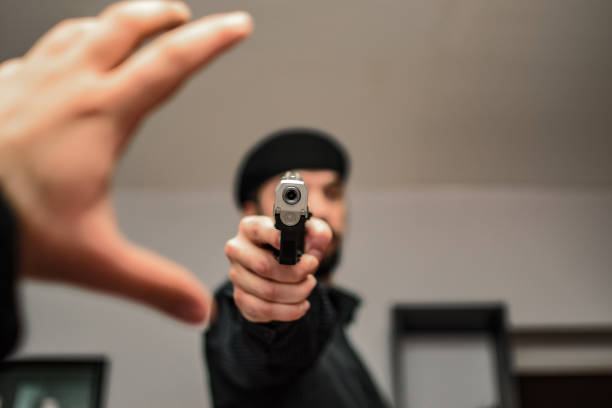 istock Young armed detective working on a case in apartment where potential murder has occured 1355329406