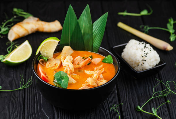 tom yam soup with black tiger shrimp, calamari, salmon and coconut milk - sopa tom yum imagens e fotografias de stock