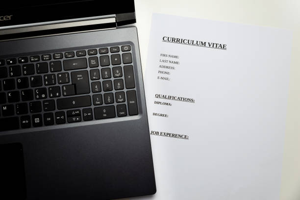 istock Laptop with resume form beside it. 1355337024