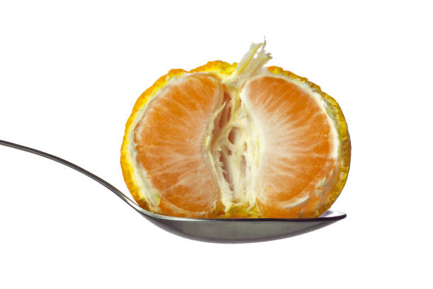 istock Half of tangerine in spoon isolated on white 1355338186