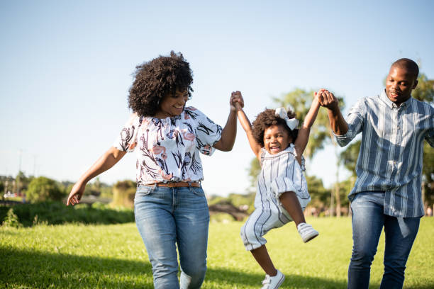 istock Parents playing with their daughter outdoors 1355338271