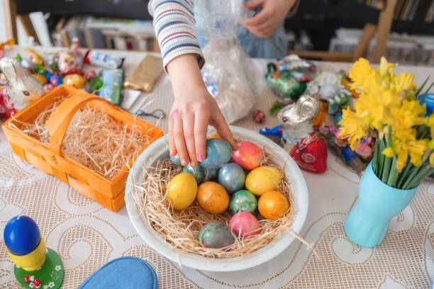 kleine mädchenhände, die buntes ei aus dem osterkorb nehmen - breakfast easter yellow easter egg stock-fotos und bilder