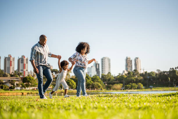 市立公園で午後遅くに散歩する家族 - family mother outdoors grass ストックフォトと画像
