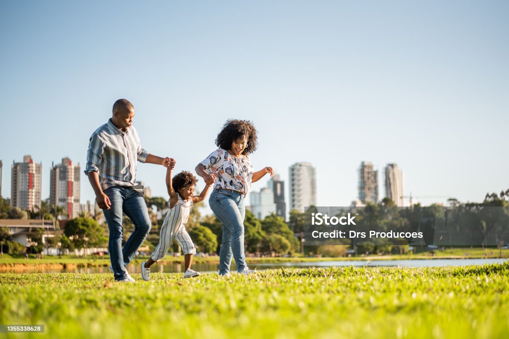 Family strolling in the late afternoon in the city park Family Stock Photo