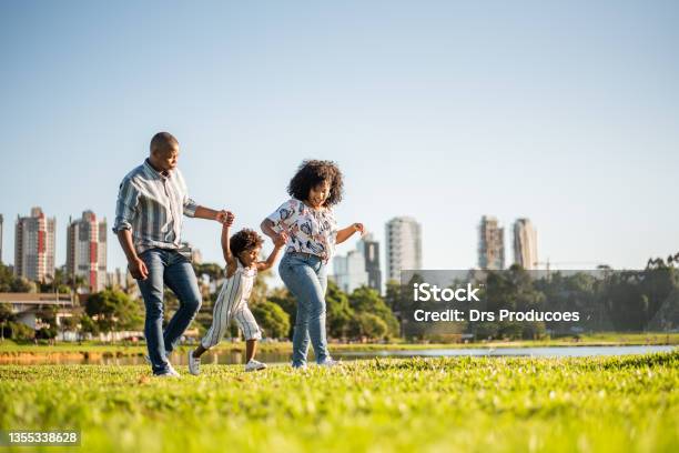 Family Strolling In The Late Afternoon In The City Park Stock Photo - Download Image Now