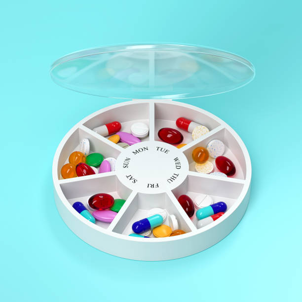 istock Round pill box with different tablets and vitamins for a week. Medication organiser. 3d rendering. 1355339850