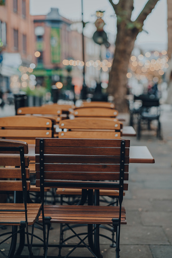 Empty outdoor cafe tables on a sidewalk in London, UK, selective focus.