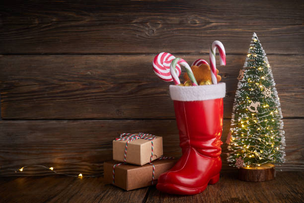 weihnachtsmannstiefel mit süßigkeiten und geschenken zum nikolaustag am 6. dezember. - nikolaus stiefel stock-fotos und bilder
