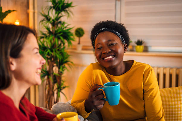 istock Female friends drinking coffee at home 1355347292