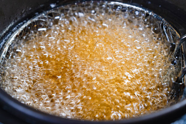 top view. oil boiling in deep fryer. in fryer cook shrimp in batter or potatoes. top view. oil boiling in a deep fryer. in the basket of the fryer cook shrimp in batter or potatoes. gadgets for the kitchen. cooking seafood in boiling vegetable oil. food state preparation shrimp prepared shrimp stock pictures, royalty-free photos & images