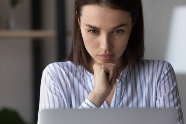 istock Close up confident thoughtful woman looking at laptop screen 1355358053