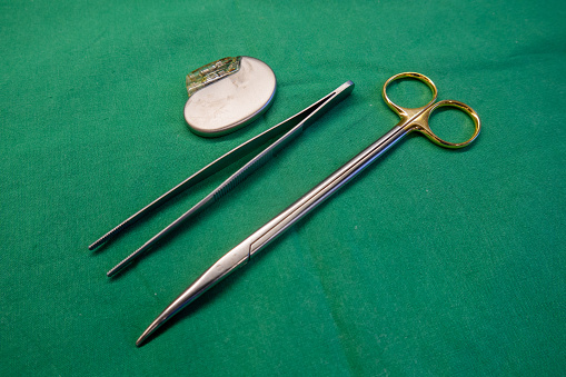 A female's hand holding dental instruments