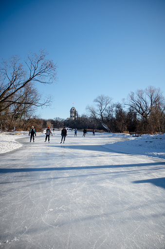 Winnipeg Manitoba Canada - January 4th 2021 / The Winnipeg locals are enjoying the freshly groomed ice of the duck pond at the Assiniboine park.