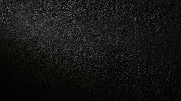 Macro shot of detailed black leather background. Dark textured close-up on quality leather parchment. stock photo
