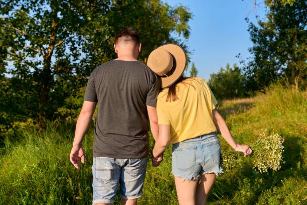 istock Happy romantic middle age couple, walking together holding hands, back view 1355361194