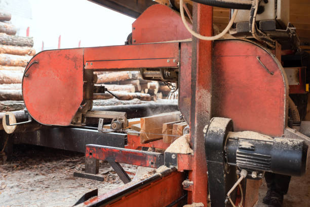 istock Processing wooden boards at a sawmill. In the process of processing logs on the equipment of the sawmill, a tree trunk is cut into planks. 1355362431